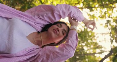 Doğada uyum, yaz günü ellerini kaldırarak rahatlayan kadın, dikey video.