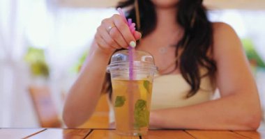 Kafede kokteyl karıştıran ve içen bir kadın.