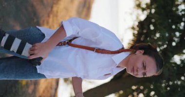 Kadın profesyonel fotoğrafçı elinde deri kayışlı bir kamera, dikey video.