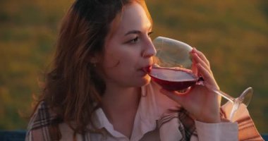 Gün batımında şarap içen kadın.