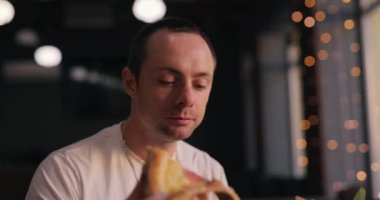 Kafede pizza yiyen bir adam, ağır çekim.