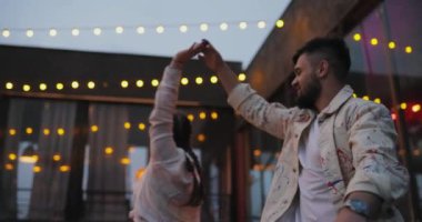 Şefkatle dans eden genç çift, ağır çekimde.