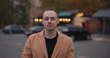 Büyük kameralı bir adam şehirde fotoğraf çekiyor, ağır çekimde.