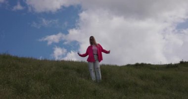 Minimalizm, pembe elbiseli komik kız çayırda dans ediyor bulutların arkasında