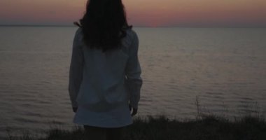 Tepeden denize bakan bir kadın rahatlatıcı.