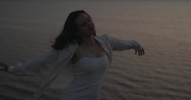 Özgürlük kadını, akşam vakti denizin üzerindeki bir tepede dinleniyor.