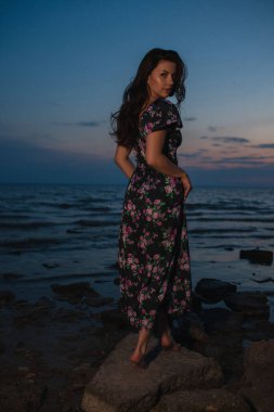 Gece gölün kenarında dikilen elbiseli kadın.