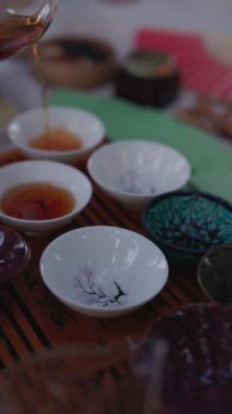 Çay seremonisi sırasında fincanlara çay dökmek, dikey video