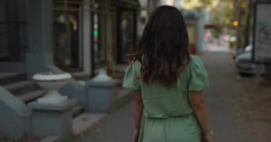 Güzel bir kadın yüzünü çeviriyor. Şehirde saçlarını savuruyor. Ağır çekimde.