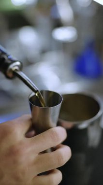 Barmen elleri barın üzerine kokteyl, alkol ve dikey video hazırlar.