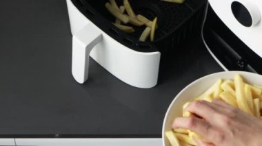 Fritözde patates kızartması pişiren bir kadın. Basit bir yemek.