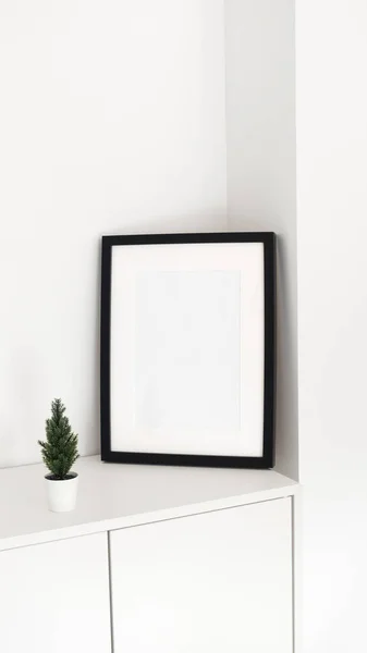 Minimalist black white picture frame with Christmas tree decor. Interior poster mock-up, vertical