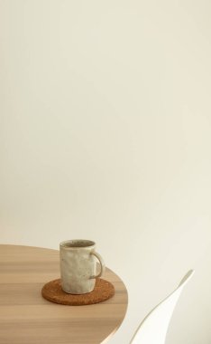 Bej seramik kupa minimalist ahşap yemek masası sabah kompozisyonu. Kahve ya da çayla dolu fincan.
