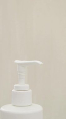 Kadın eli pompalı kozmetik üreticisi şişesi kullanıyor. Şampuan, duş jeli, ya da sıvı sabun şeffaf doku güzellik üreticisi, dikey