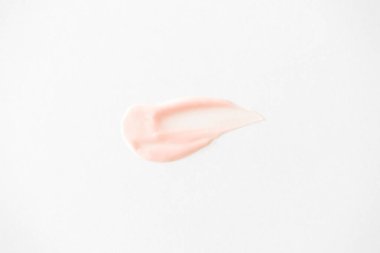 Beyaz üzerine pembe dudak parlatıcısı lekesi. Asgari güzellik ürünü dudak kremi vuruşu