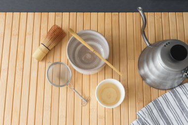 Bambu paspasın üzerine geleneksel kibrit çay hazırlama seti. Minimalist estetik kompozisyon sakin, zen esinlenilmiş yaşam tarzı, refah, Japon kültürü, çay ayinleri ve farkındalık içeriği.