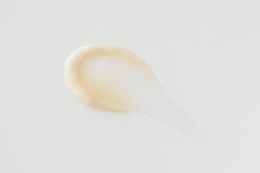 Beyaz arkaplanda minimalist bej sürme kremi