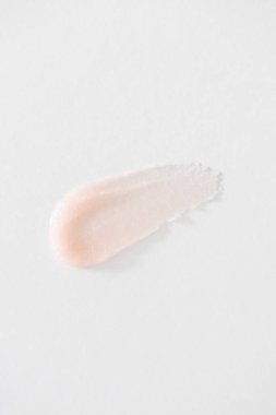 Minimum pembe dudak kremi örneği, yakın plan. Kremsi, hafif parlak doku hidrasyon, beslenme, ve minimalist güzellik cilt bakımı, dudak bakımı, veya temiz güzellik markalaşması