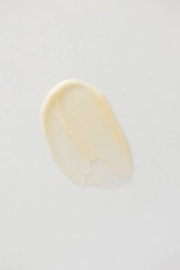 Beyaz arka planda C vitamini kremi lekesi. En az cilt bakım ürünü dokusu, dikey