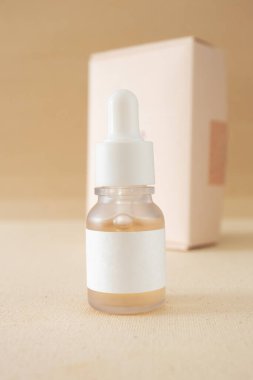 Yaşlanma önleyici yüz serumu şişesi minimum kozmetik cilt bakımı arka planda dikey kutulu güzellik ürünü modeli. Cilt bakımı kavramı