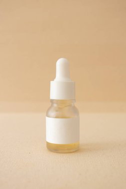 Bej kanva arka planında serum şişesi organik doğal cilt bakım ürünü maketi, minimum estetik