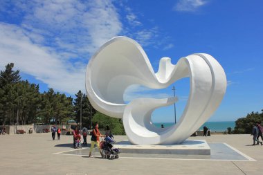 Zirve. Azerbaycan. 09.05.2016. Beyaz güvercin, deniz kenarındaki bir parkta barışın sembolüdür..