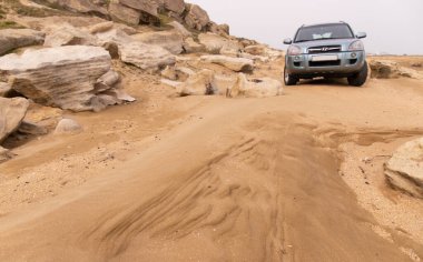 Dyubyanda. Azerbaycan. 03.17.2021. Deniz kenarında güzel bir plajda araba..