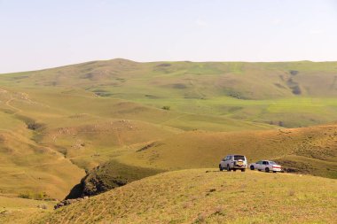 Sundu. Shamakhi bölgesi. 04.25.2021. Azerbaycan. Güzel yeşil dağlarda iki araba.