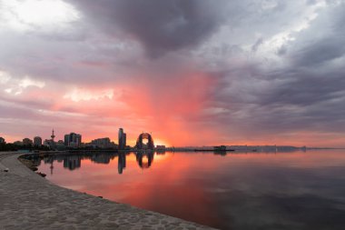 Bakü. Azerbaycan. 07.30.2021. Şehrin üzerinde bulutlu bir havada kızıl gün doğumu.