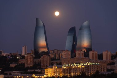 Azerbaycan. Bakü. 06.25.2021. Şafakta Flem Kuleleri üzerinde sarı ay.