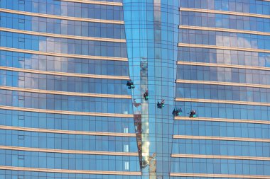 Bakü. Azerbaycan. 09.27.2021. Asılı kablolardaki insanlar otelin camlarını siler..