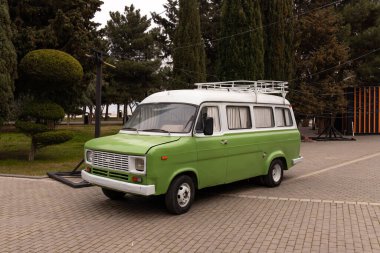 Bakü. Azerbaycan. 03.22.2023. Şehir bulvarında duran antika yeşil bir minibüs..