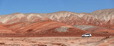 Khizi bölgesi. Azerbaycan. 04.17.2022. Güzel kırmızı dağlarda beyaz araba.