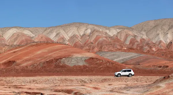 Khizi bölgesi. Azerbaycan. 04.17.2022. Güzel kırmızı dağlarda beyaz araba.