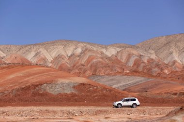 Khizi bölgesi. Azerbaycan. 04.17.2022. Güzel kırmızı dağlarda beyaz araba.