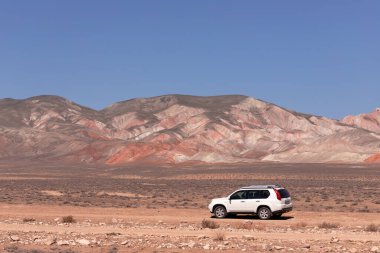 Khizi bölgesi. Azerbaycan. 04.17.2022. Güzel kırmızı dağlarda beyaz araba.