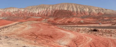 Khizi bölgesi. Azerbaycan. 04.17.2022. Güzel kırmızı dağlarda beyaz araba.