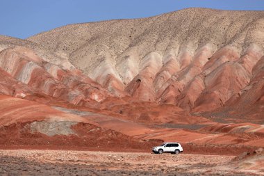 Khizi bölgesi. Azerbaycan. 04.17.2022. Güzel kırmızı dağlarda beyaz araba.