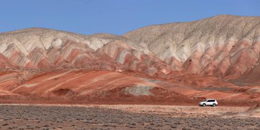 Khizi bölgesi. Azerbaycan. 04.17.2022. Güzel kırmızı dağlarda beyaz araba.