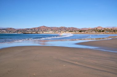 Gökkuşağı Ventura, CA 'daki kumlu plajda kırılma dalgasında ortaya çıkıyor..