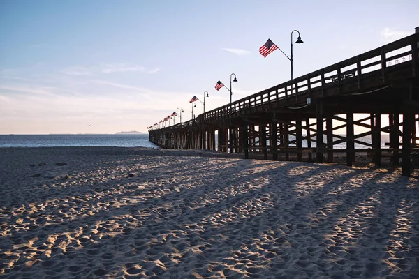 文图拉码头向远方倾斜 为美国感恩节装饰着美国国旗 晚霞在沙滩上投下醒目的阴影 — 图库照片