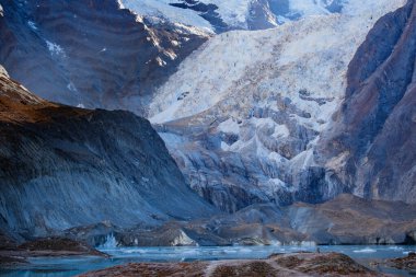 Annapurna Kuzey Buzulu Narchang Gölü 'ne düşer ve yüzeyde küçük buz kütleleri yüzer. Annapurna Kuzey Ana Kampı, Nepal.