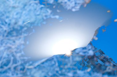 Image of sun rising over flank of Annapurna 1 and creating sunburst is blended in an in-camera double exposure with ice on nearby lake. clipart