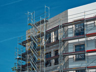 Dışarıdan iskelesi olan yüksek katlı bir binanın yeni inşaatı.