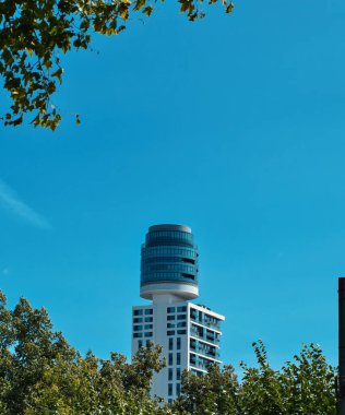 Frankfurt 'ta bir gökdelen, ofis binası. En üst katında silindirik bir yapısı olan mavi gökyüzü.