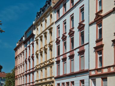 Dış cephelerinde güzel, dekore edilmiş pencereleri ve farklı renkleri olan tarihi binaların yan görüntüsü.