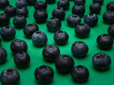 Yeşil arkaplandaki tek böğürtlenler sıra halinde birbirlerinden uygun mesafede sıralanır.