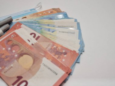 Sağlık sisteminin masrafları için bir sembol olarak bir banknot ve tıbbi maske yakın plan.