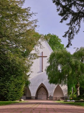 Almanya, Bielefeld 'de ağaçların arkasında bir mezarlık şapeli.