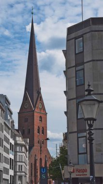 Hamburg 'daki binalar arasındaki tarihi kırmızı kilisenin dikey görüntüsü.